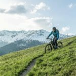 person-riding-through-mountains-on-riese-muller-superdelite-mountain-ebike