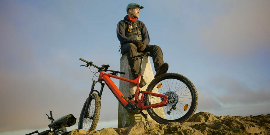 Dan sat on a trig point with a Delite Mountain Bike